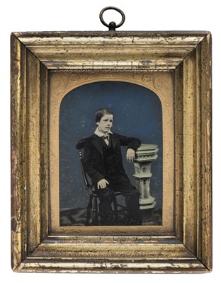 Lot 487 - Quarter-plate ambrotype of a seated boy against a blue background