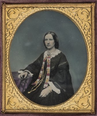 Lot 333 - Sixth-plate tinted ambrotype of a woman seated by a table
